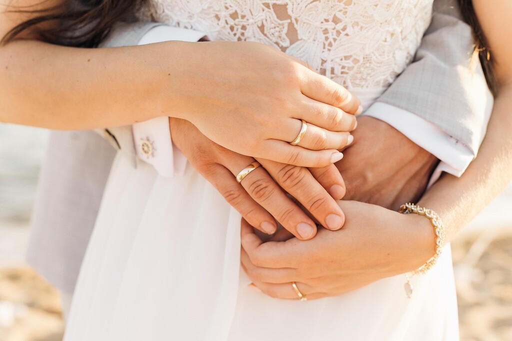 casal de mãos dadas sobre a barriga da noiva