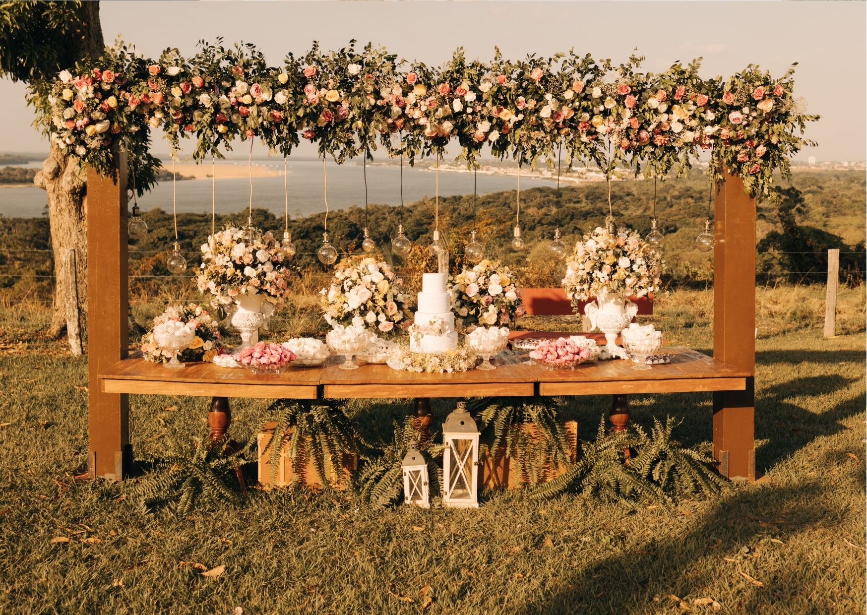 Mesa com bolo de casamento no campo