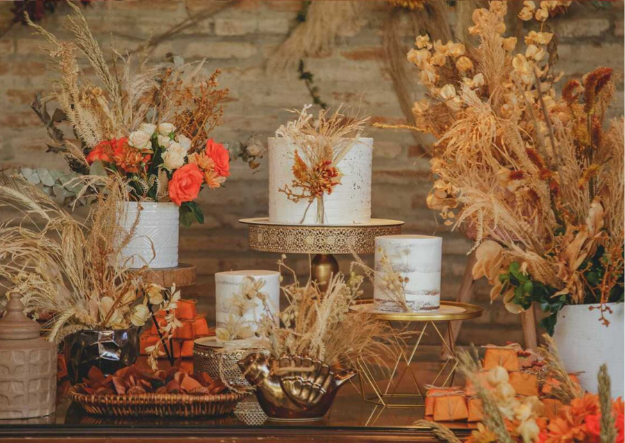 Mesa com flores secas e bolos de casamento