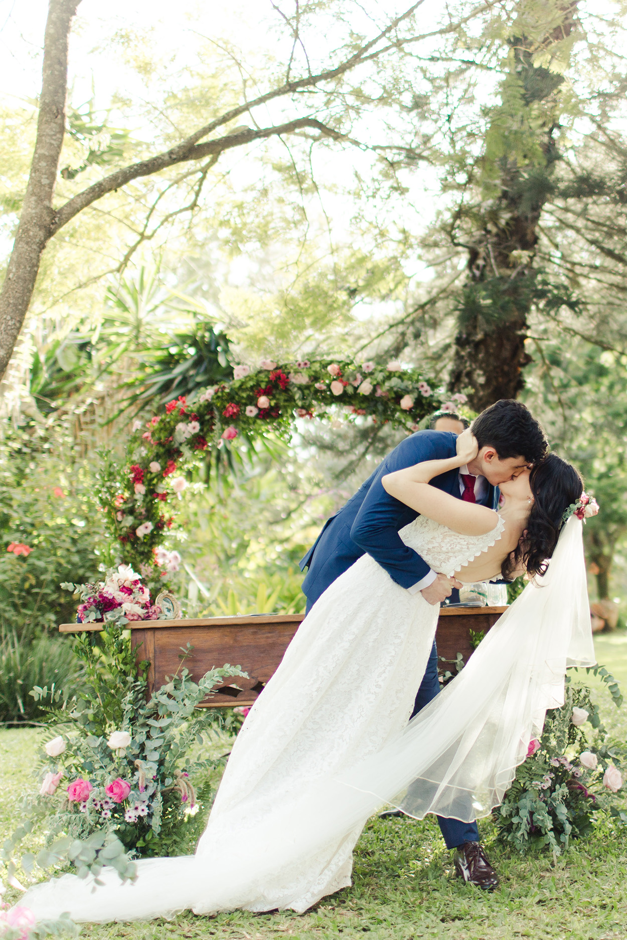 Noivos se beijando perto do altar florido