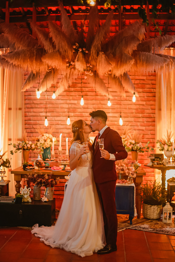 capa post: Noivos se beijando em salão decorado