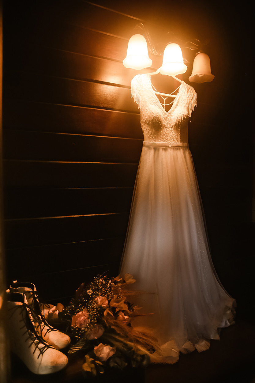 Vestido de noiva no cabide e buquê
