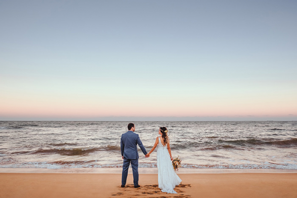 capa post: fornecedor de casamento na praia. Casal de noivos pisando na areiaem frente ao mar