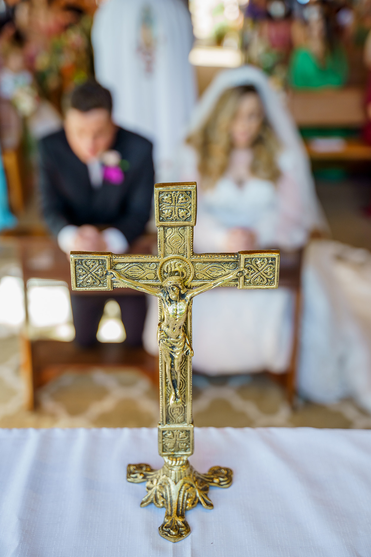 Crucifixo e noivos ao fundo