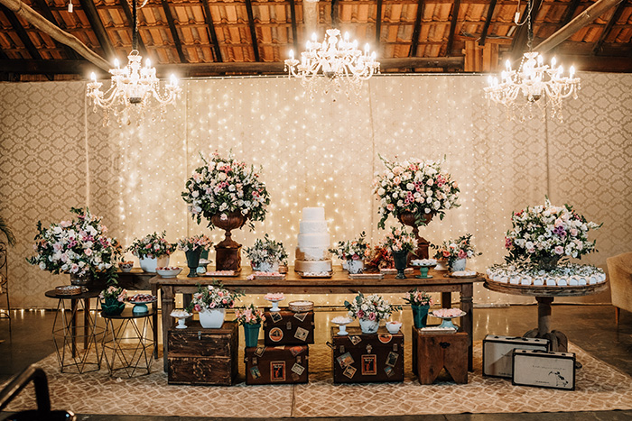 Mesa com bolo, doces e flores