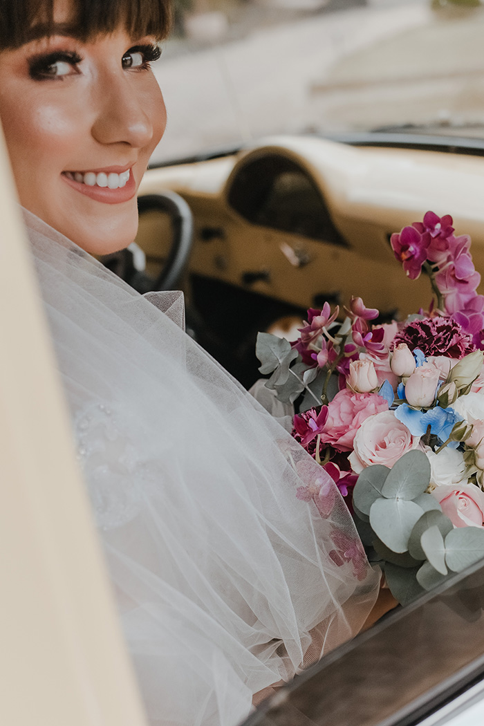 Noiva sorrindo com buquê de flores rosa e azul
