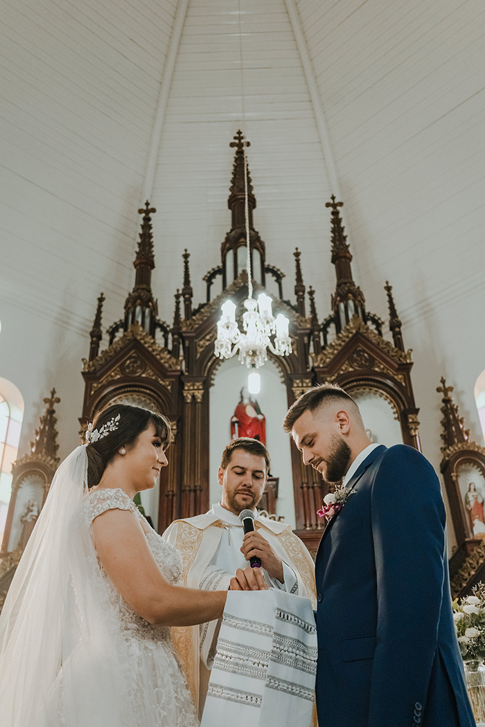 Padre e noivos diante do altar