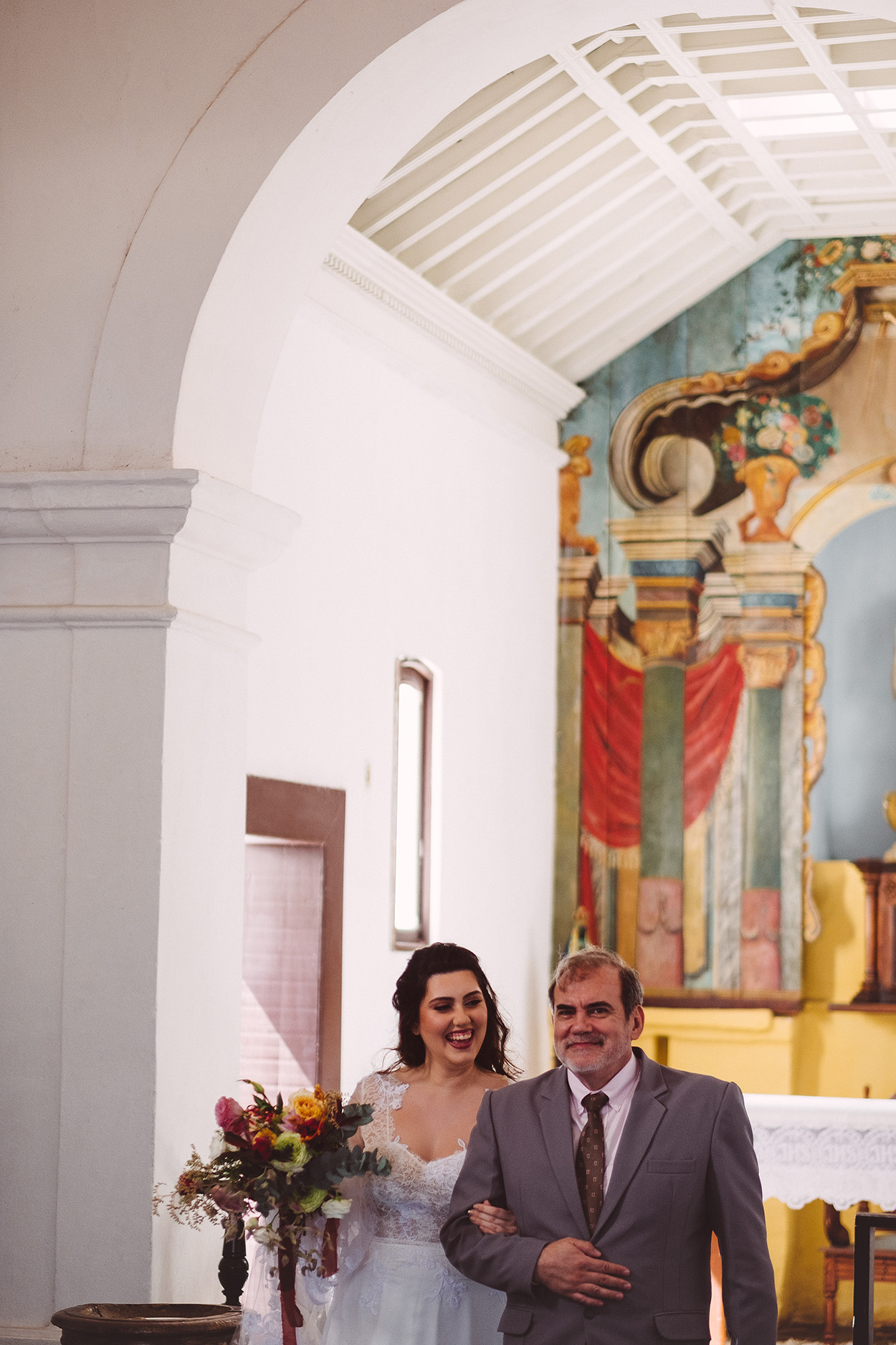 Noiva e homem de terno cinza na igreja
