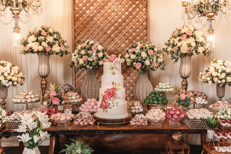 Mesa com bolo de casamento, doces e flores
