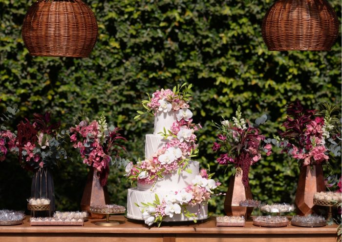 Mesa com bolo de casamento branco com flores