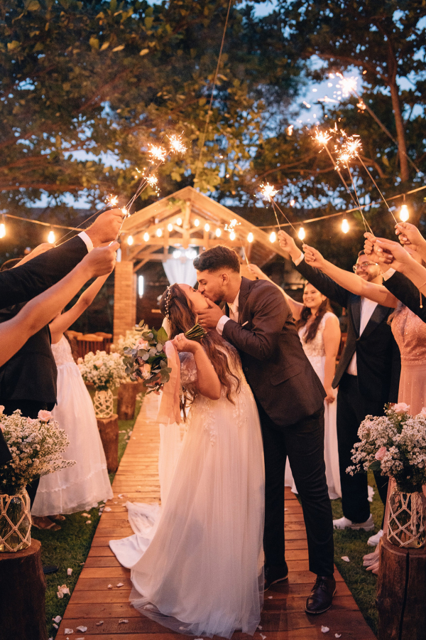 capa post: Noivos se beijando e convidados com sparklers
