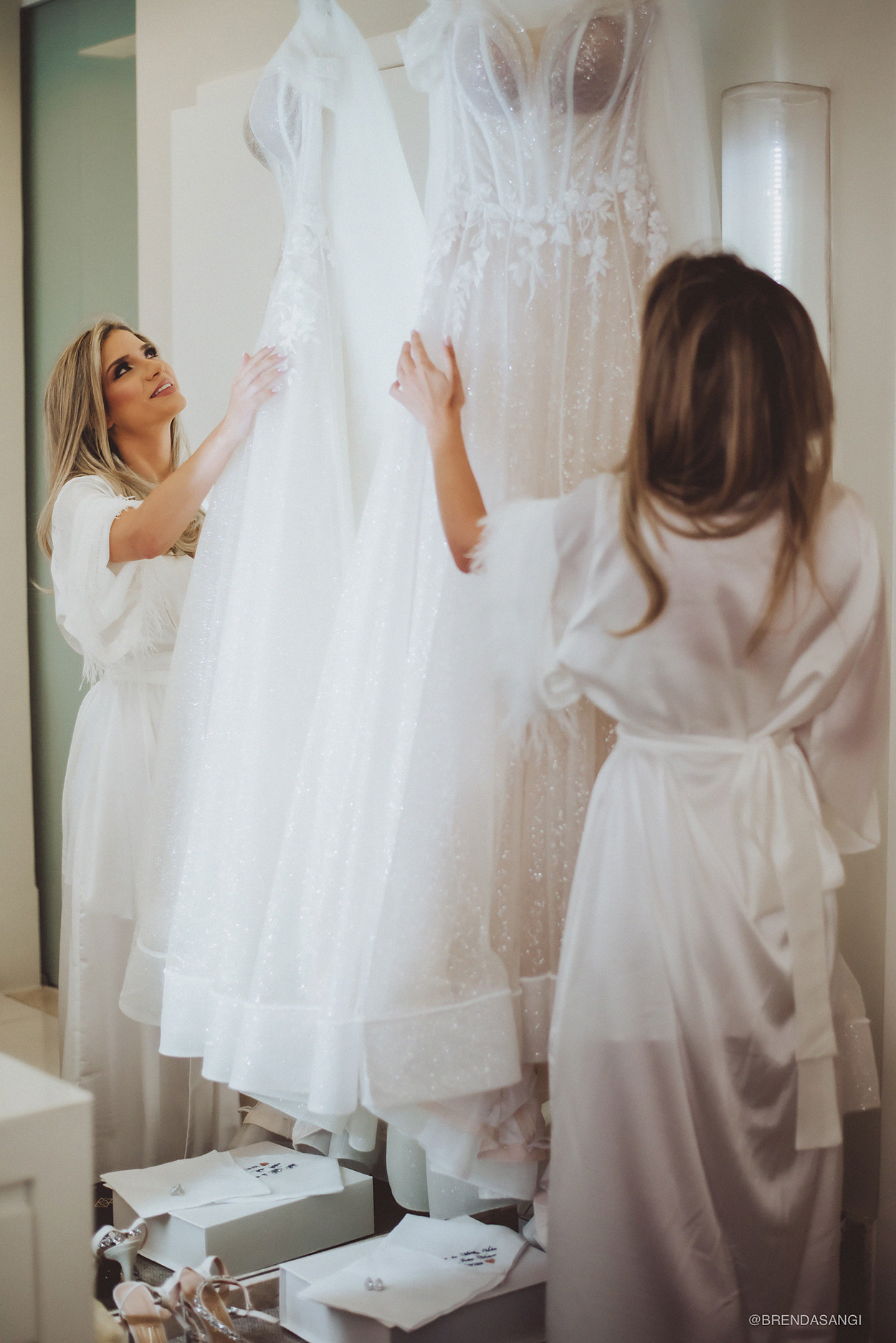 Noiva olhando seu vestido branco