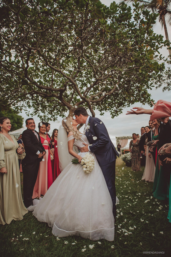 capa post: Noivos se beijando e convidados comemorando