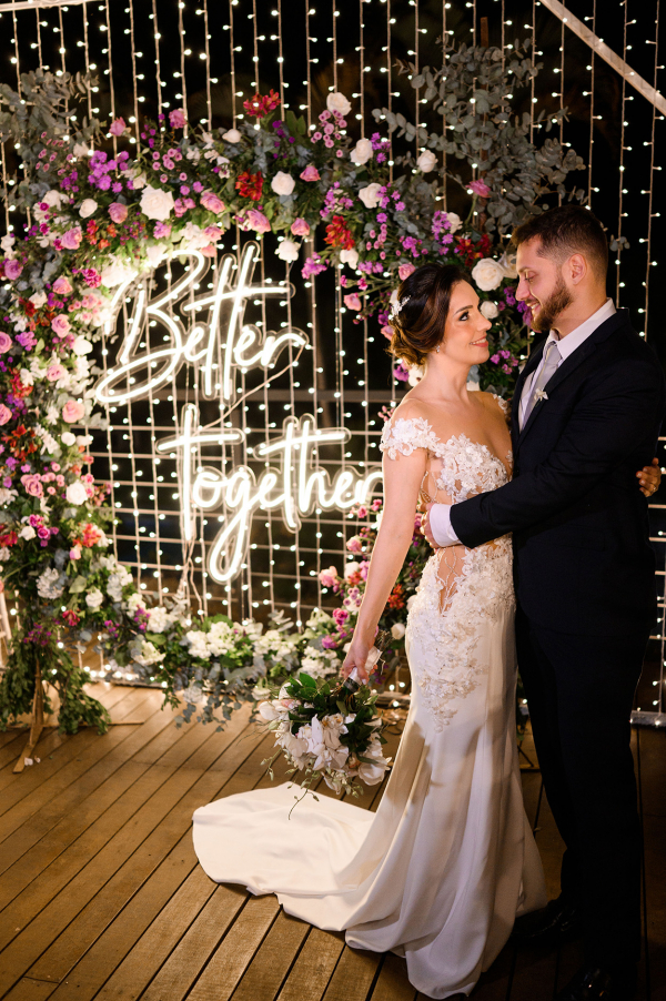 capa post: Noivos perto de painel luminoso