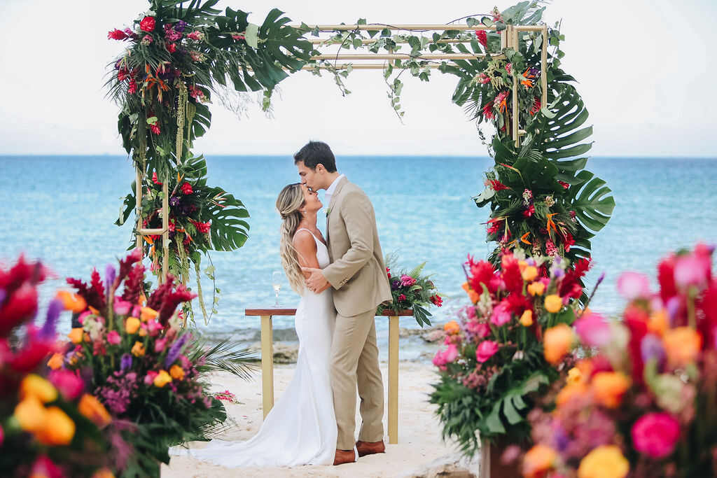 noivos se beijando em casamento pé na areia no caribe