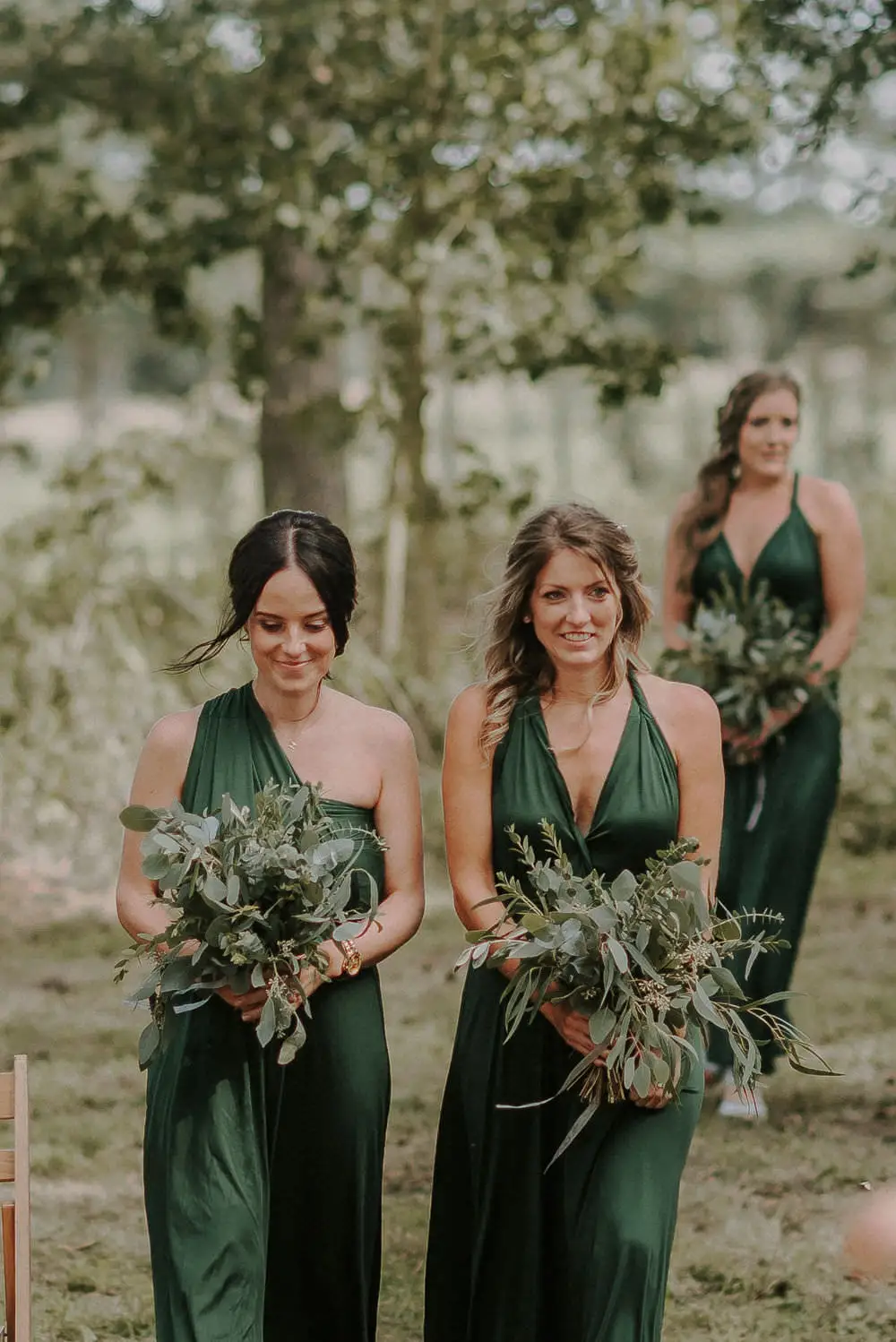 demoiselles de vestido verde entrando em cerimônia de casamento
