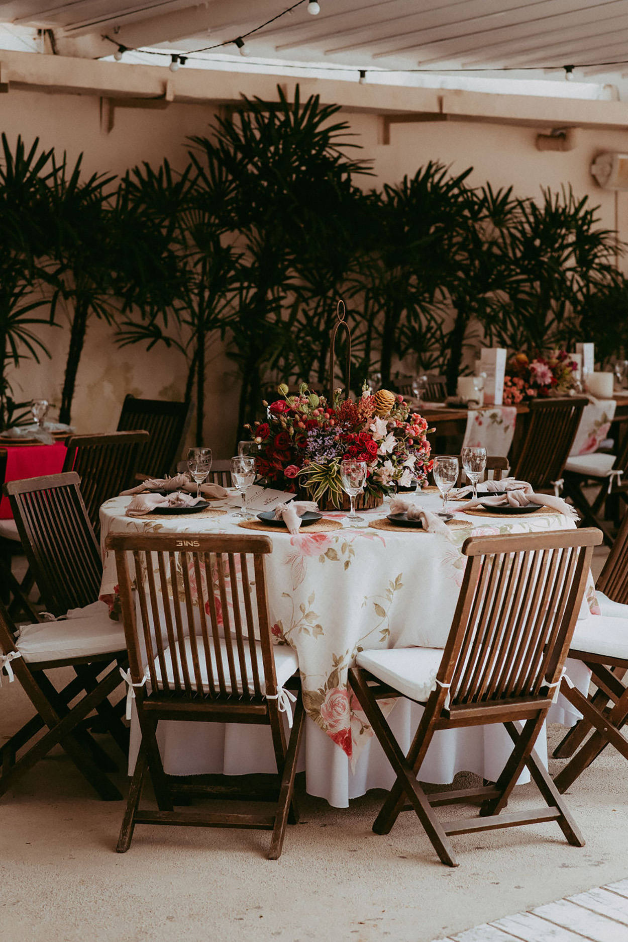 Mesa com toalha floral e centro de mesa