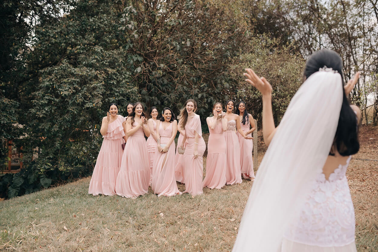Noiva e madrinhas com vestido rosa no campo