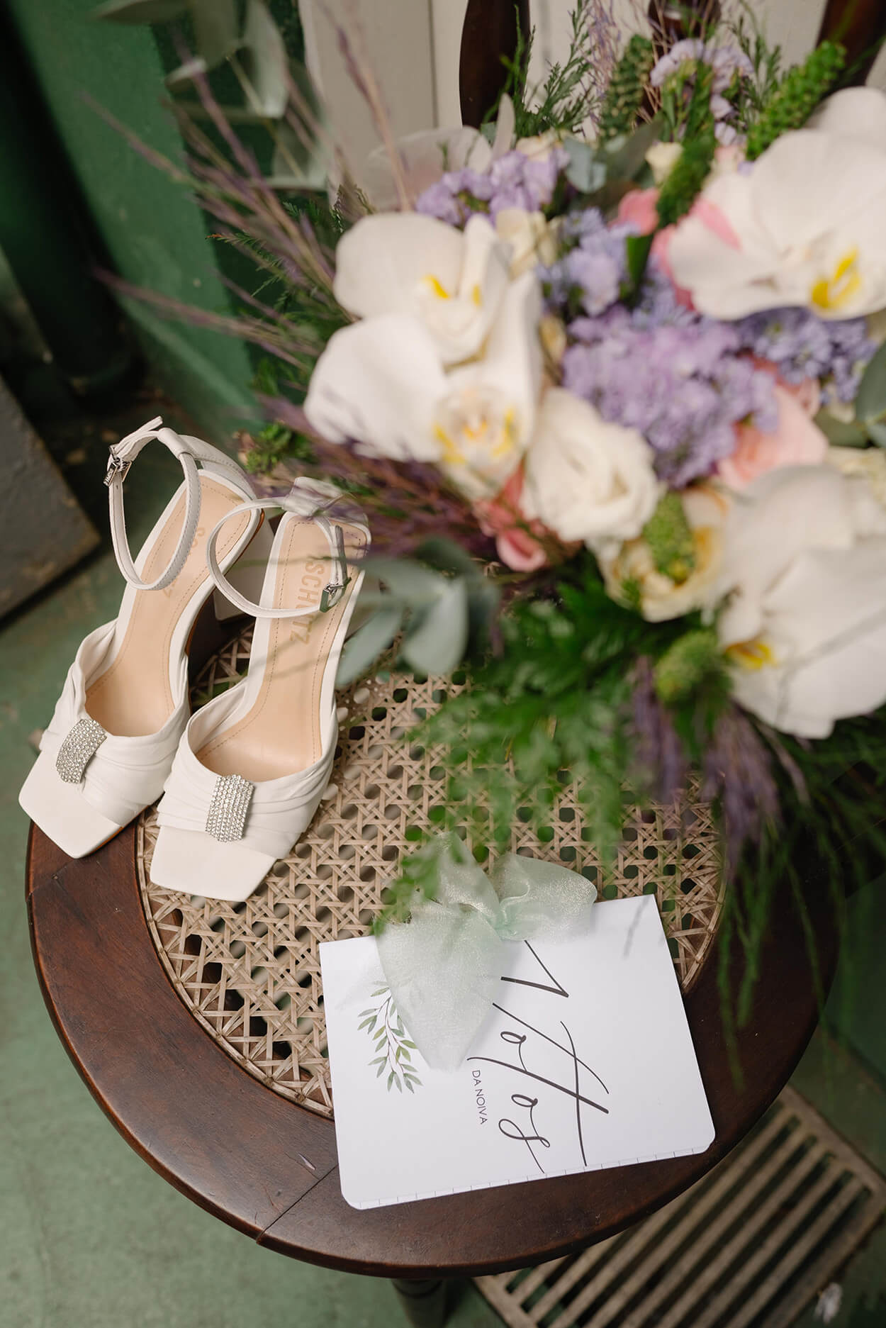 Mesa com flores e sandália da noiva