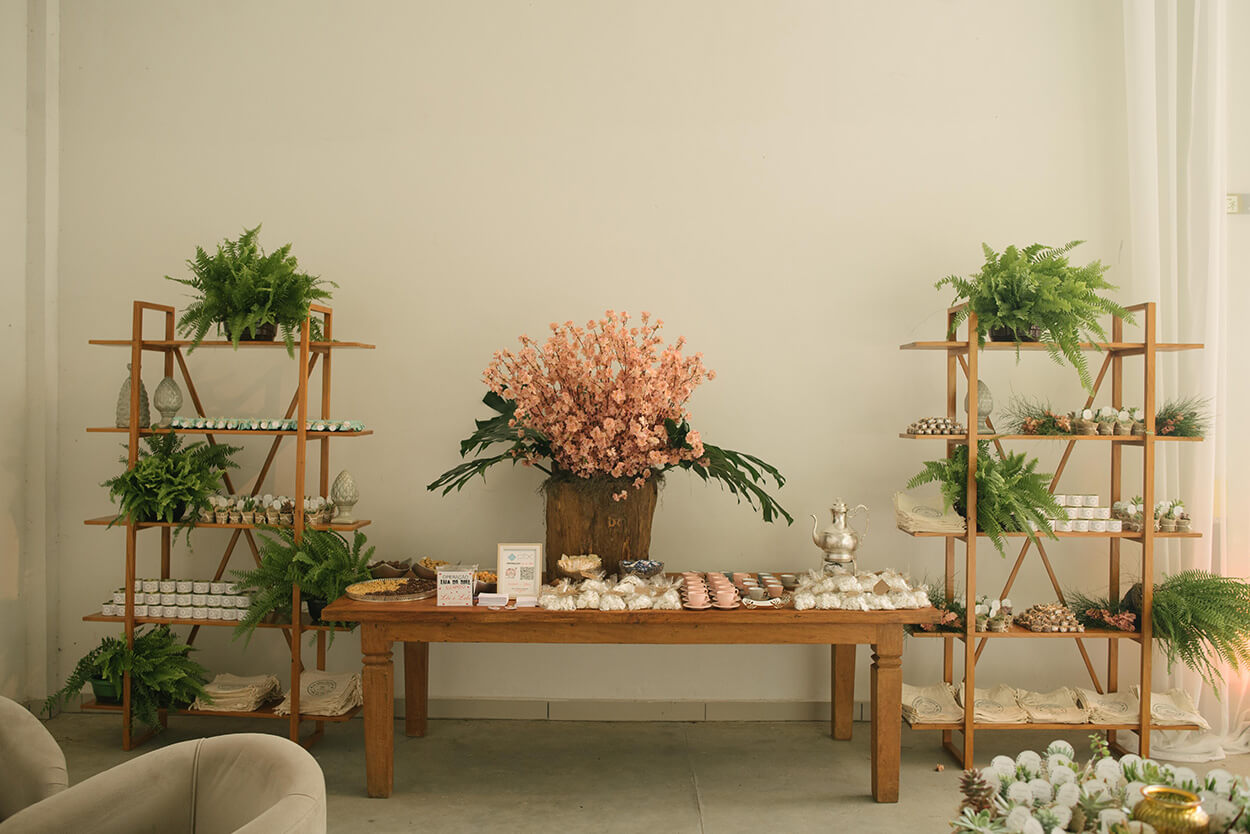Mesa e estante decoradas com plantas e lembrancinhas