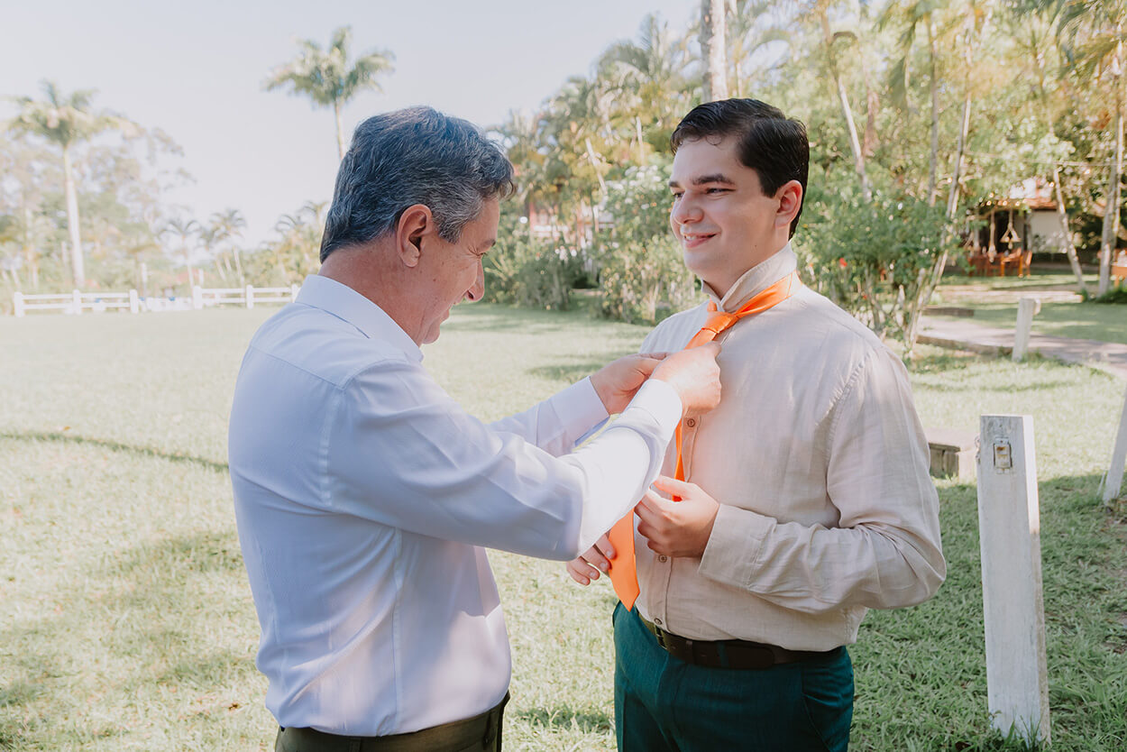 Pai do noivo ajustando a gravata do noivo