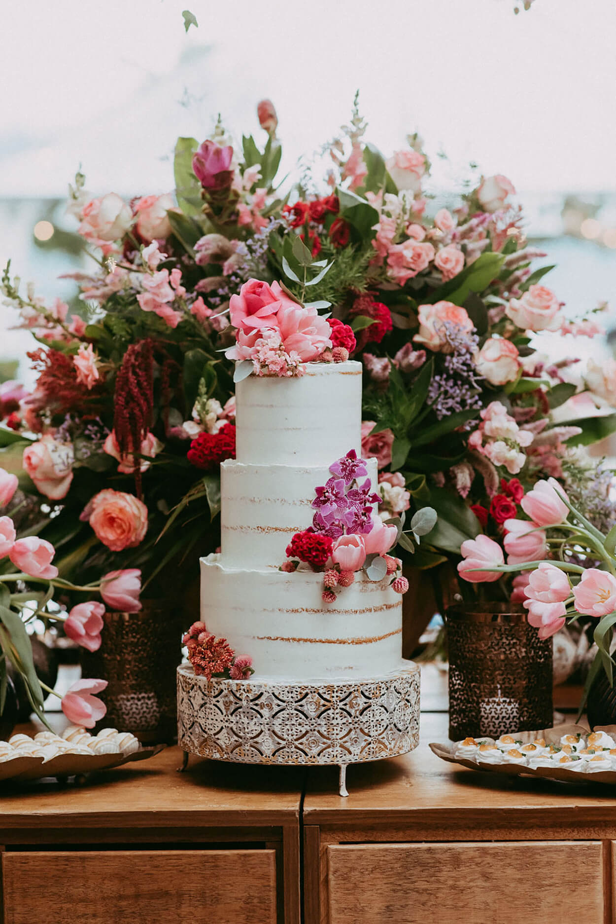 Mesa com flores e bolo de casamento de três andares