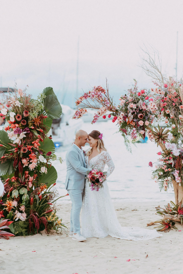 capa post: Noivos abraçados no altar na praia