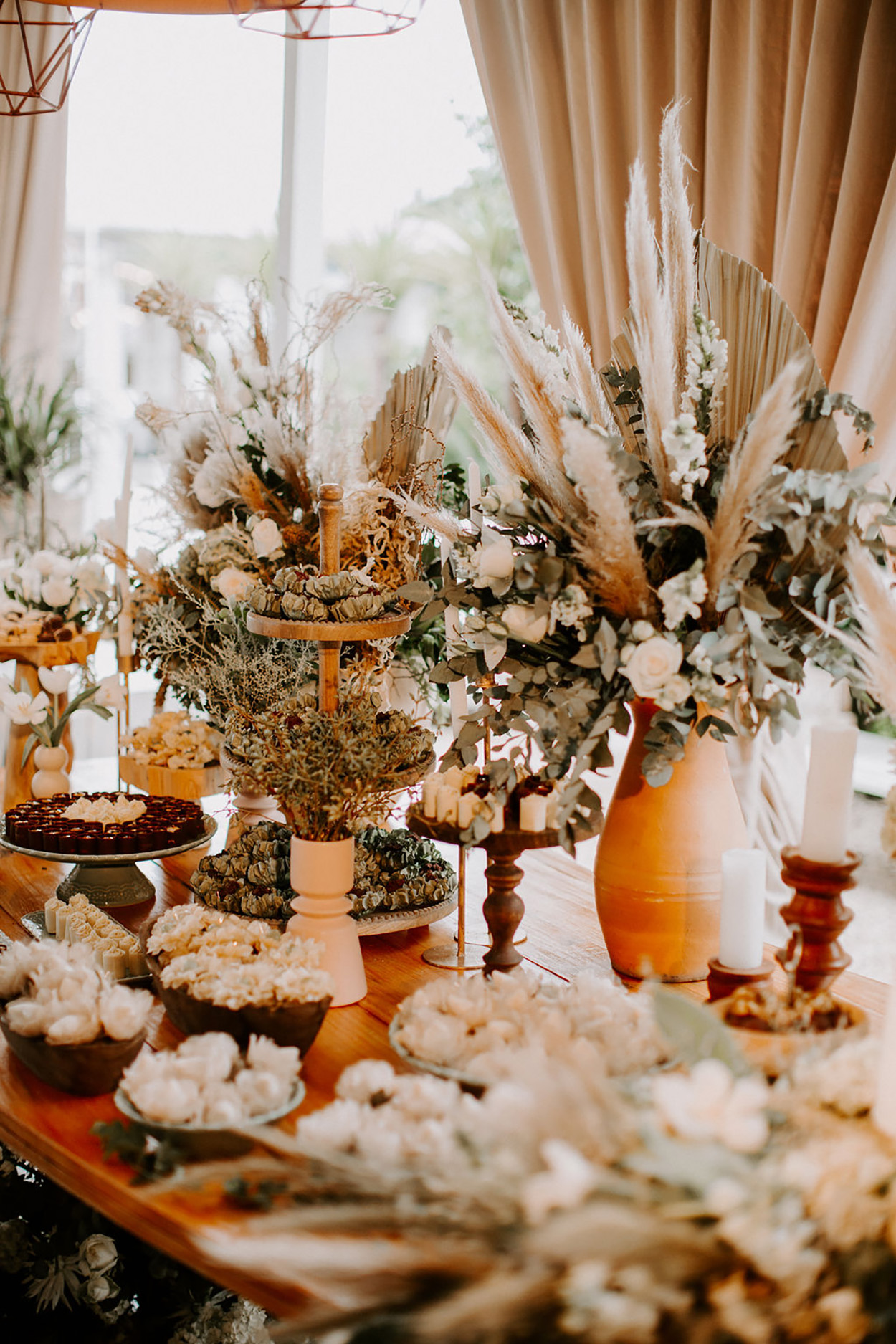 Mesa com vasos de flores e doces