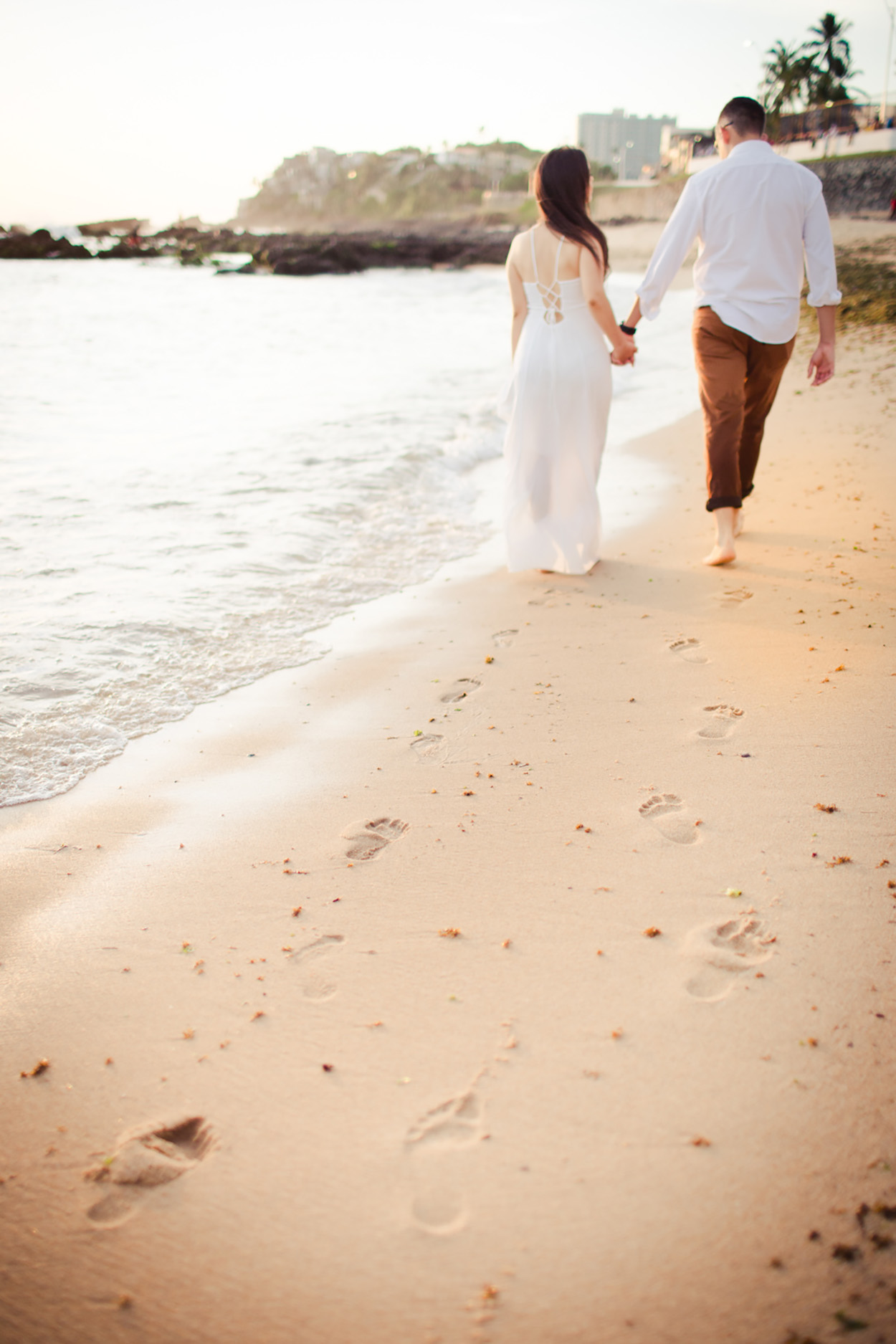 Casal de costas caminhando na praia