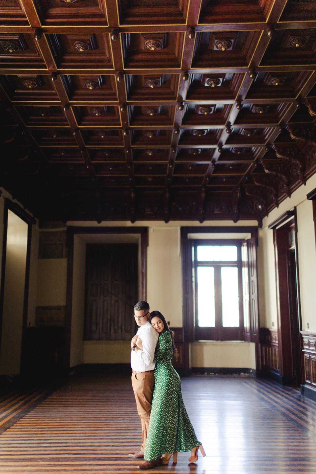 Casal abraçado em salão antigo