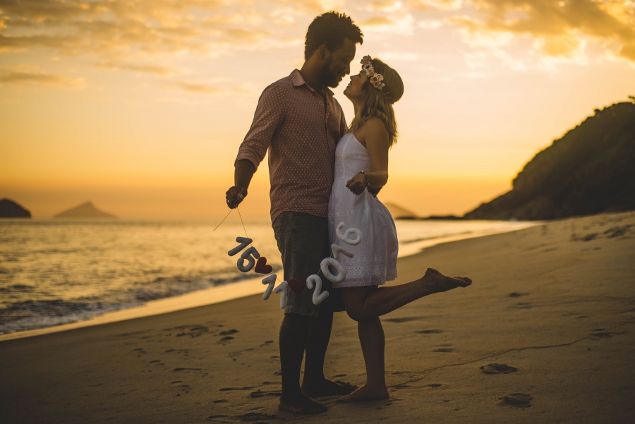 casal em ensaio pré wedding na praia durante o por do sol