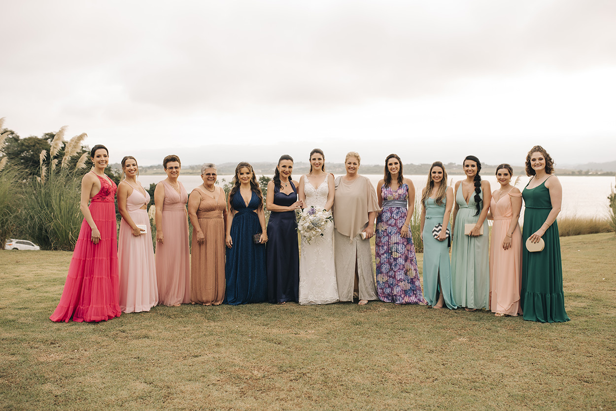 Noiva e madrinhas com vestidos coloridos no campo