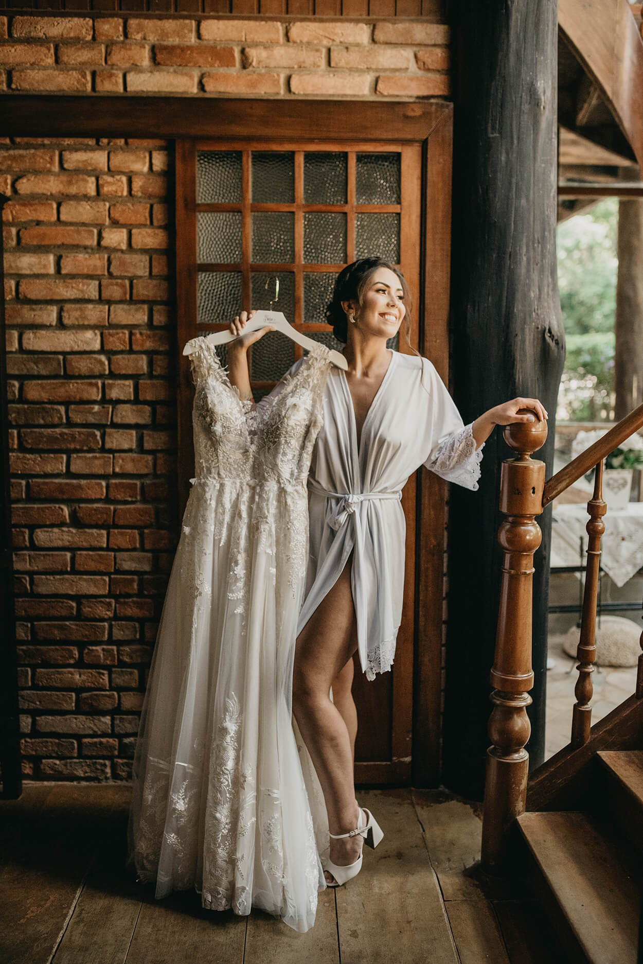 Mulher com robe segurando vestido de noiva