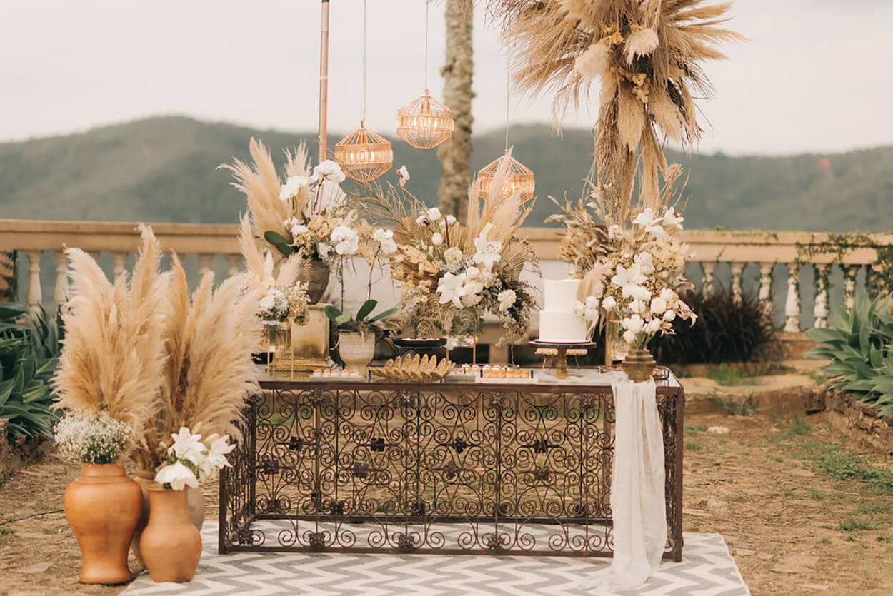 Mesa com bolo de casamento e flores brancas