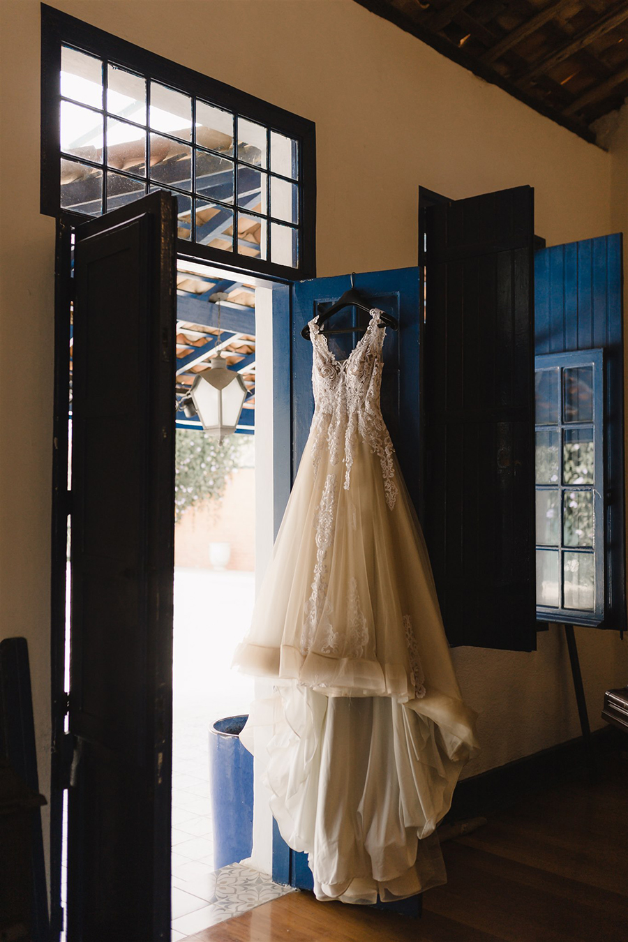 Vestido de noiva pendurado na porta