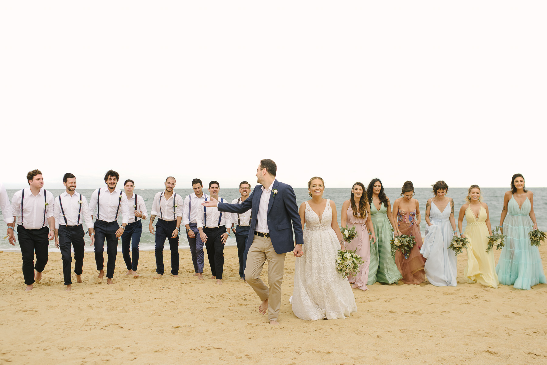 padrinhos e madrinhas de casamento andando na praia descalços