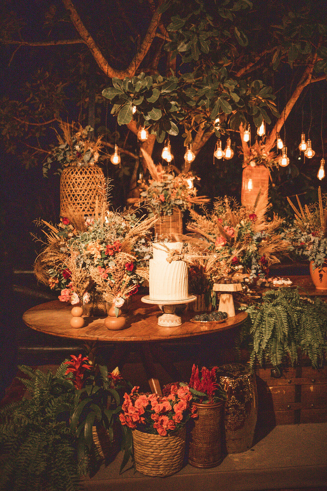 Mesa com flores e bolo de casamento