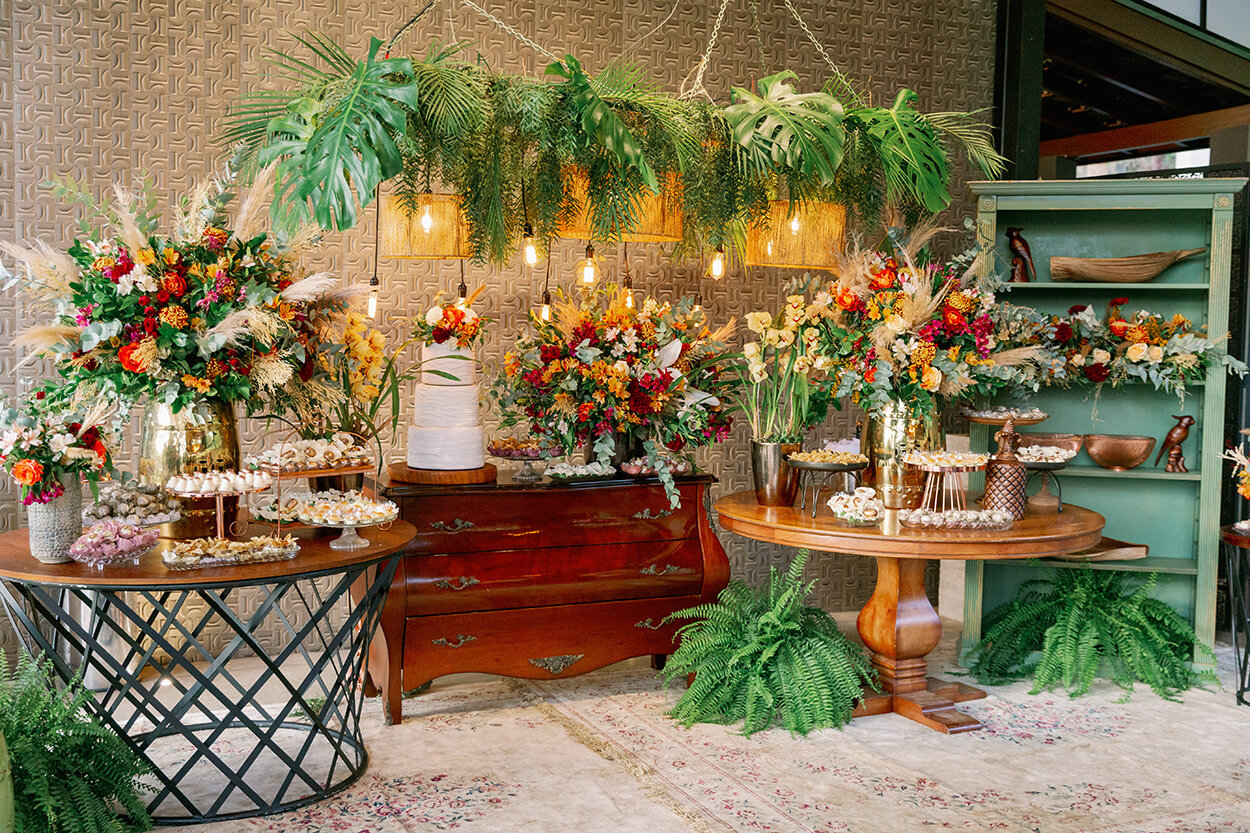 Mesas com flores e bolo