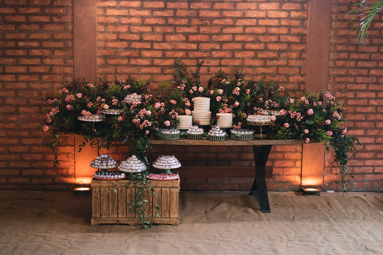 Mesa com bolo de casamento e flores rosas