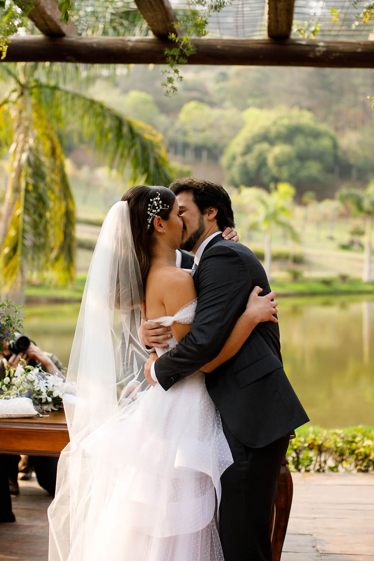 Noivos se beijando no casamento no lago