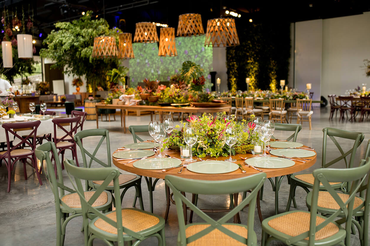 salão para festas com iluminação natural e mesa posta delicda com flores rosa