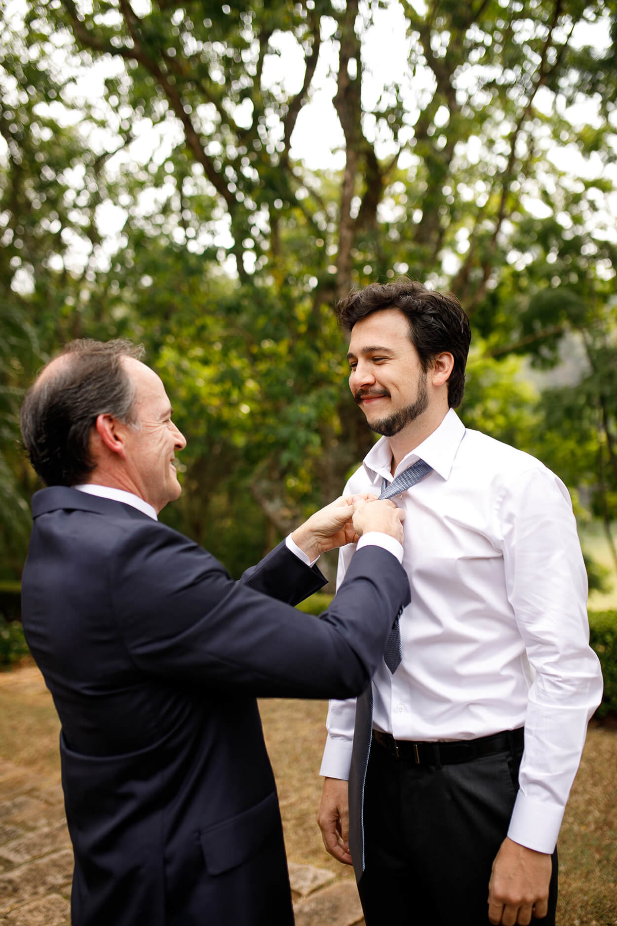 Pai do noivo ajustando a gravata do filho