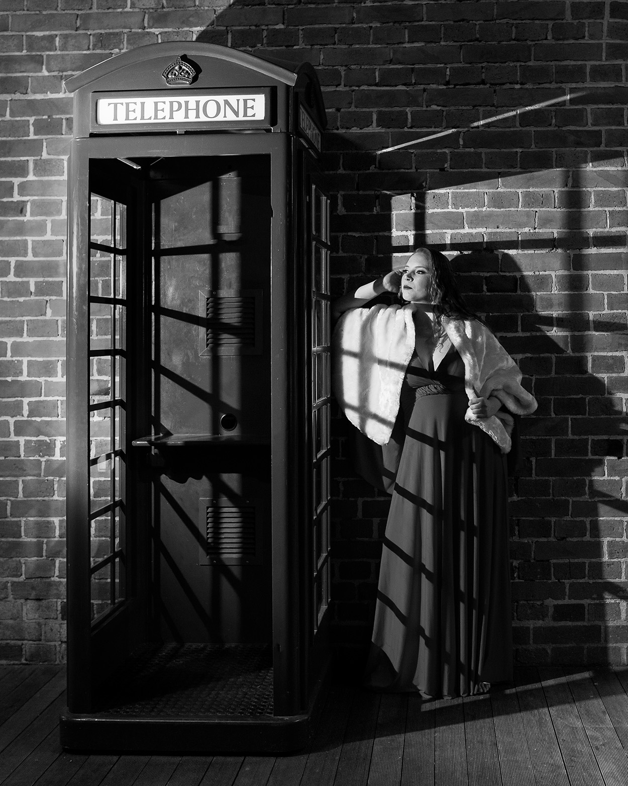 Mulher ao lado de cabine de telefone