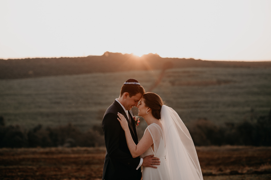 casal posa para foto em paisagem deslumbrante em casamento judaico