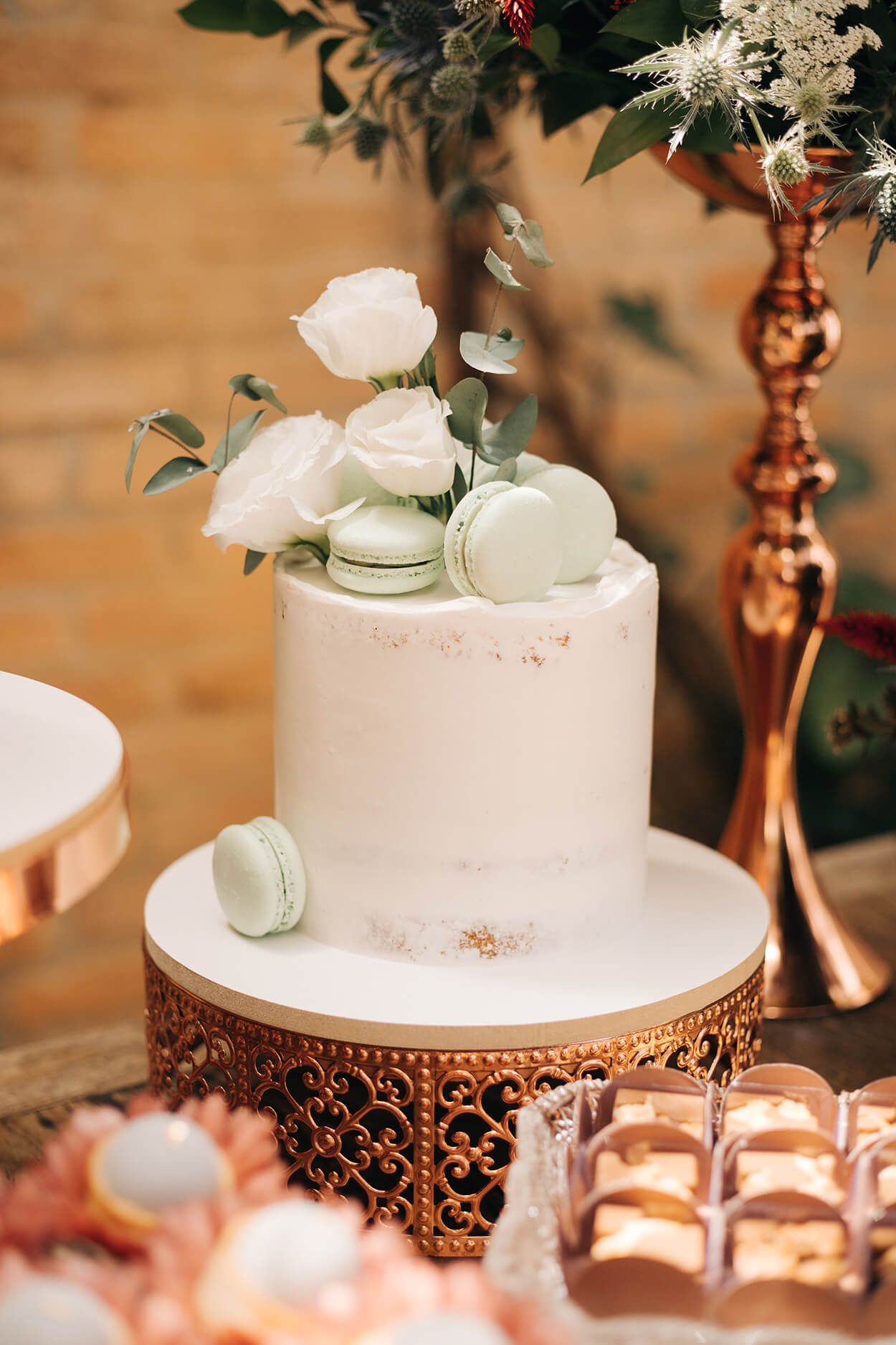Bolo de casamento branco espatulado com rosas brancass e macaroons verdes no topo
