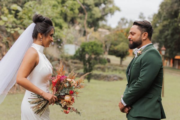 capa post: Noivo com terno verde e noiva com buquê colorido no jardim