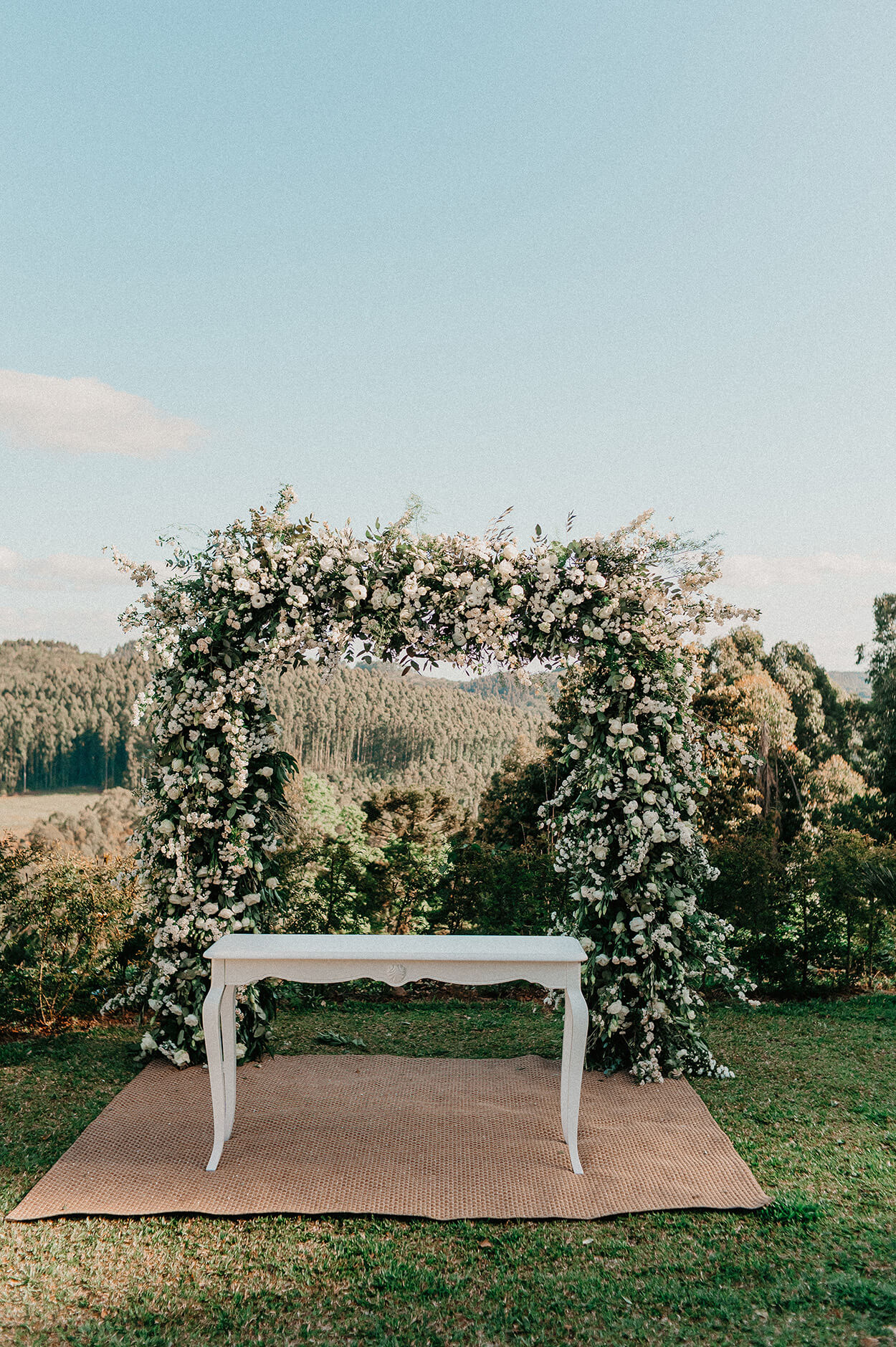 Mesa brana e altar quadrado com flores brancas nno campo
