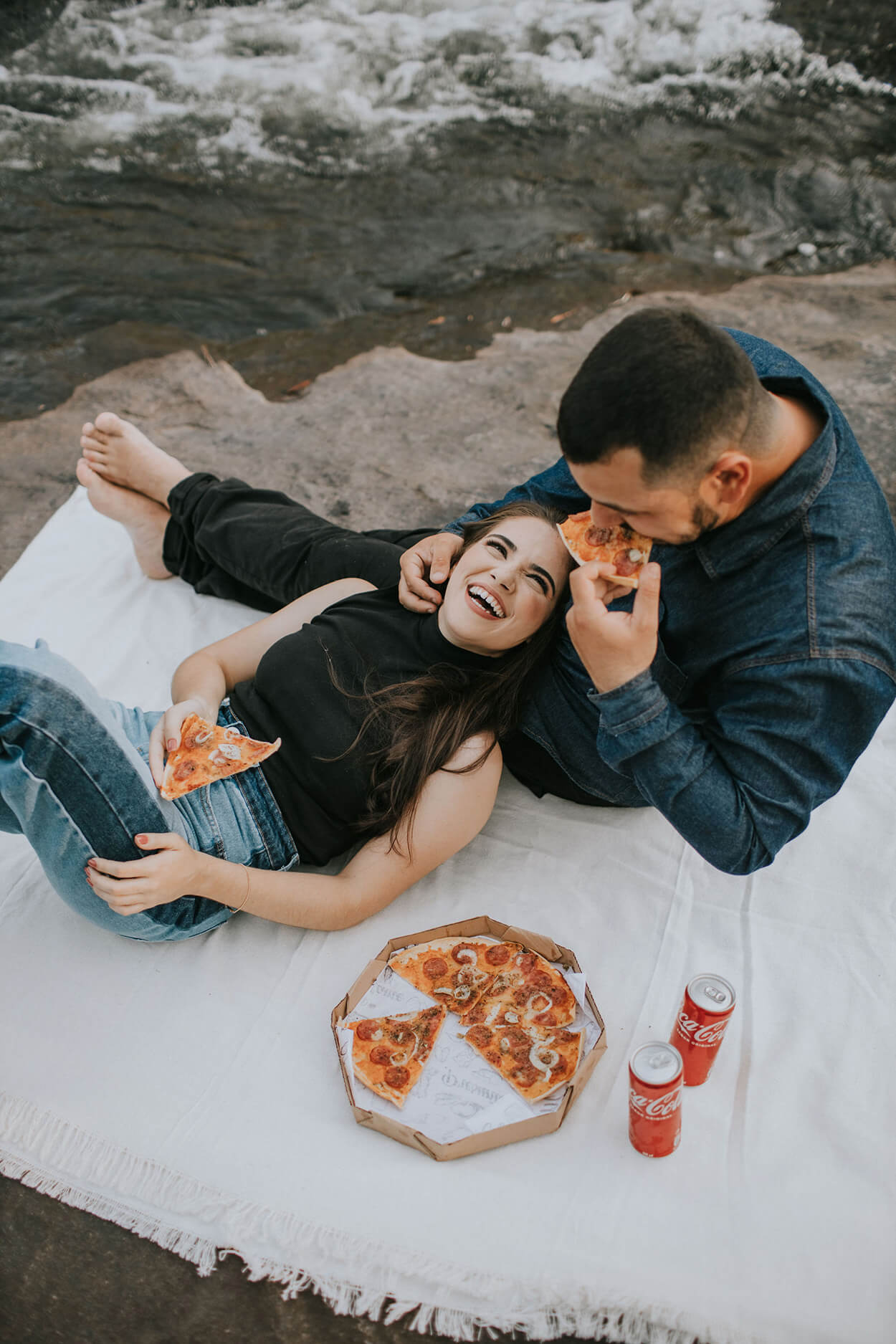 Casal animado fazendo piquenique com pizza e coca cola