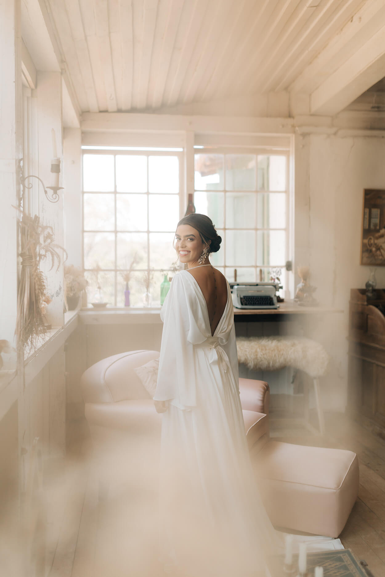 Mulher com vestido de noiva em quarto branco com estilo clássico