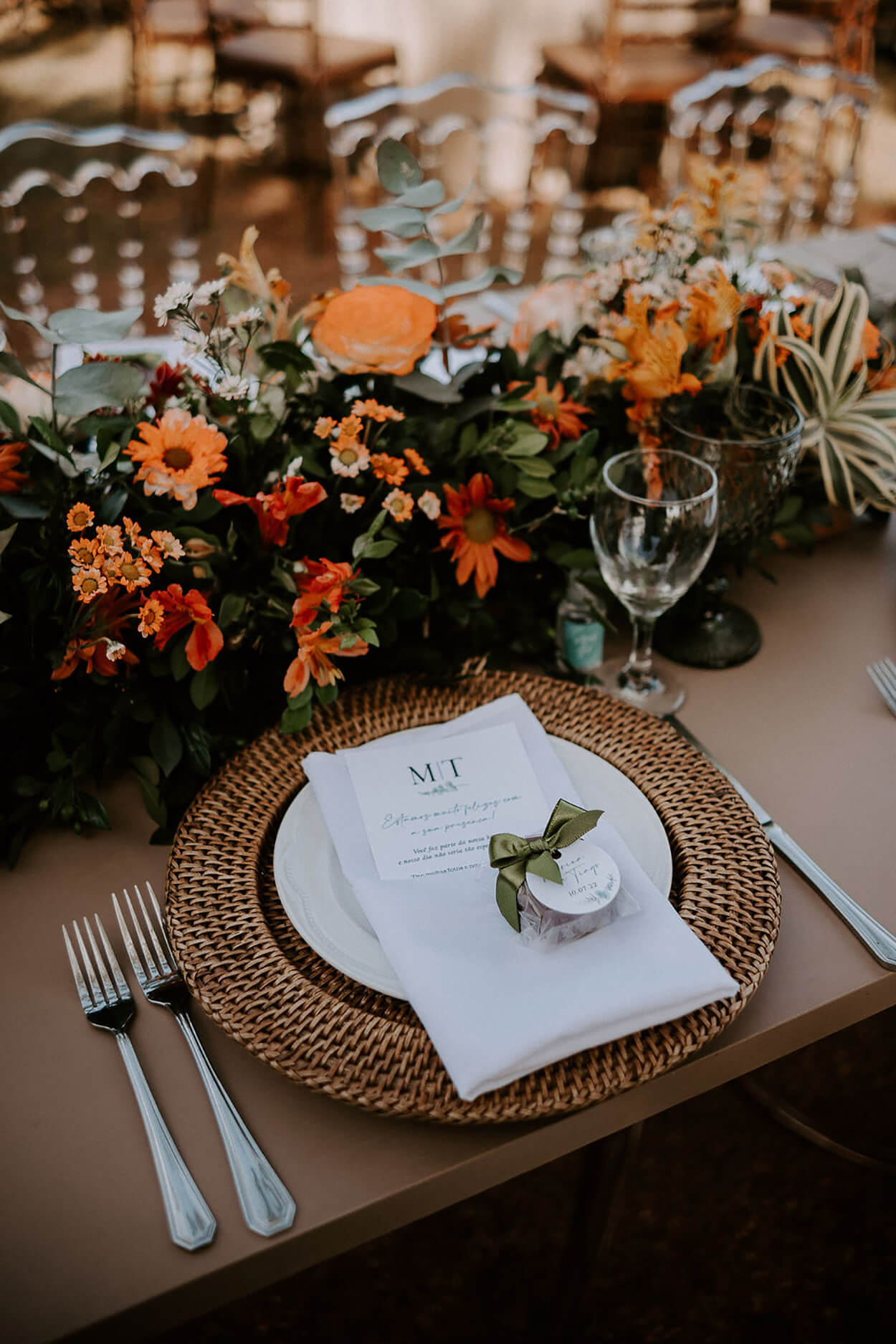 Sousplat rústico com menu branco e centro de mesa com flores laranjas